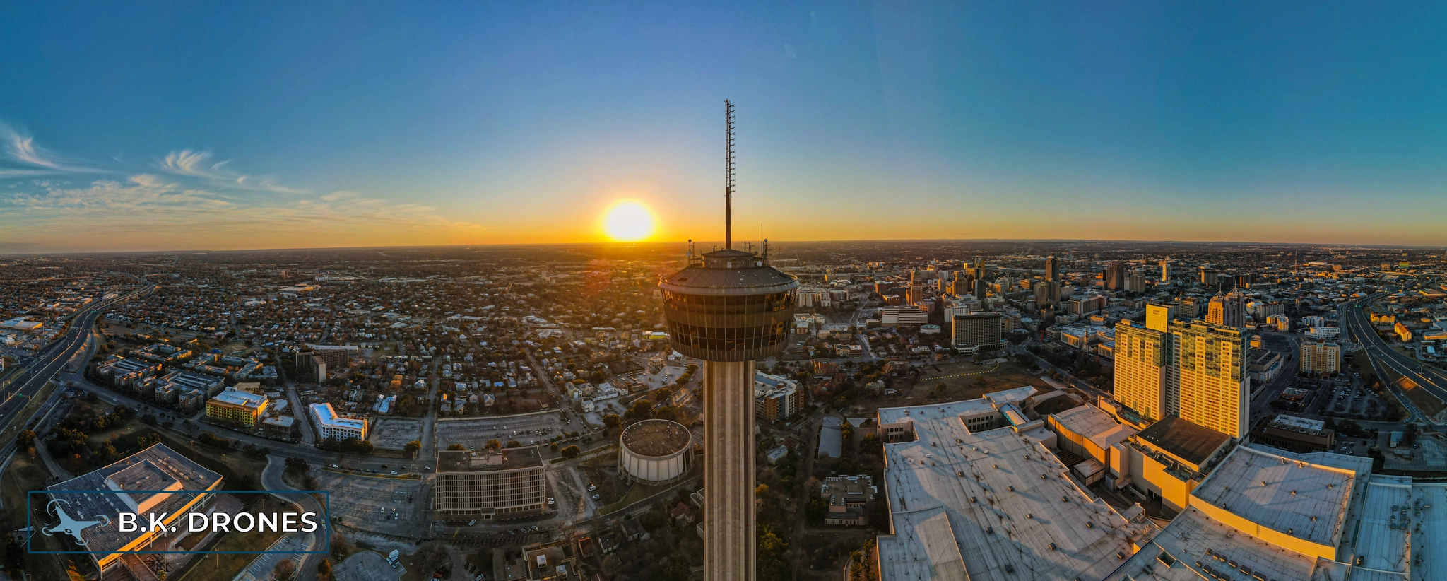 a panoramic drone image showing the Tower of the Americas in downtown San Antonio at Sunset